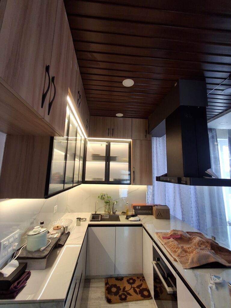 luxury modular kitchen interior design Kolkata U-shaped layout wooden ceiling fluted glass cabinets chimney LED lighting white quartz countertop